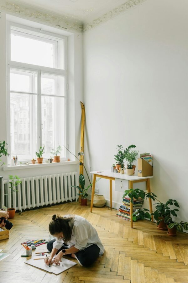 A cozy artist space featuring indoor plants and natural sunlight, perfect for inspiring creativity.
